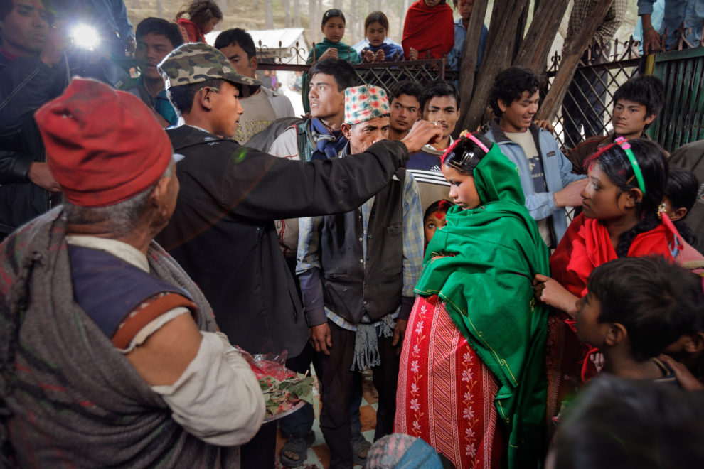 Durga, 16, applies sindoor, or vermillion powder, to his young bride Nirutas part during their wedding ceremony in Kagati village Nepal on Jan. 23, 2007, which was the auspicious day of Vasant Panchami, a Hindu holiday celebrating the coming of spring. Niruta, 14, was nine-months pregnant during the ceremony, attended by friends and relatives. Durgas father hadnt liked the idea of his son abandoning his education and marrying young, but after Durgas mothers death, the family desperately needed help in both the home and the fields. So they found a suitable young bride. The 2015 earthquakes devastated Nepal and left girls and women in an increasingly vulnerable position, leading experts to believe child marriage rates will increase over the coming years.